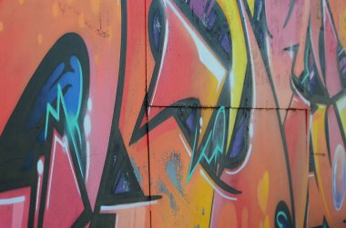 Grafiti çizimler parçası. Eski duvar boya lekeleri sokak sanatı kültür tarzı ile dekore edilmiştir. Renkli arka plan doku sıcak tonları içinde.
