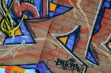 Grafiti çizimler parçası. Eski duvar boya lekeleri sokak sanatı kültür tarzı ile dekore edilmiştir. Renkli arka plan doku sıcak tonları içinde.