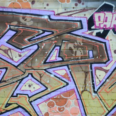 Grafiti çizimler parçası. Eski duvar boya lekeleri sokak sanatı kültür tarzı ile dekore edilmiştir. Renkli arka plan doku sıcak tonları içinde.