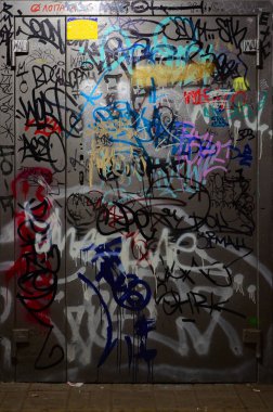 Grafiti etiketleri parçası. Eski duvar boya lekeleri sokak sanatı kültür tarzı ile bozulmuş. Boyalı metal kapı.