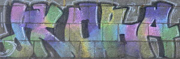 Fragment of graffiti drawings. The old wall decorated with paint stains in the style of street art culture. Multicolored background texture.