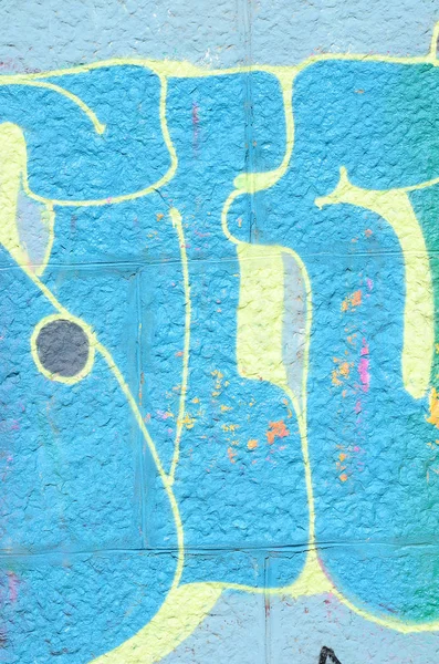 Fragment of graffiti drawings. The old wall decorated with paint stains in the style of street art culture. Colored background texture in cold tones.