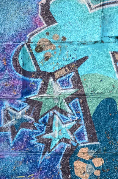 Fragment of graffiti drawings. The old wall decorated with paint stains in the style of street art culture. Colored background texture in cold tones.