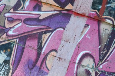Grafiti çizimler parçası. Eski duvar boya lekeleri sokak sanatı kültür tarzı ile dekore edilmiştir. Mor tonlarında renkli arka plan doku.