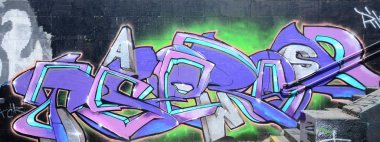Grafiti çizimler parçası. Eski duvar boya lekeleri sokak sanatı kültür tarzı ile dekore edilmiştir. Mor tonlarında renkli arka plan doku.