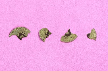 Bir pembe Polar kumaş arka plan üzerinde yalan adet bitcoin bölünür. Sonbahar ve ders kripto para biriminin çöküşü. Cryptocurrency yatırımcılar için kötü haber.