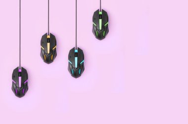 Birkaç bilgisayar faresi bir pastel pembe arka plan asmak. Kooperatif bilgisayar oyunları, auto-tıkırtı ve pay-per-click platformlar kavramı. Düz kopya alanı ile yatıyordu