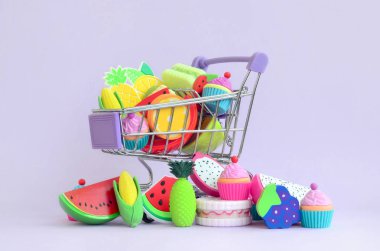 Shopping cart is filled to the top with fresh fruits on a purple background. The concept of buying food and fruit online. Diet food clipart