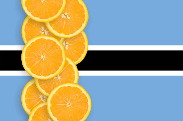 Σημαία Της Μποτσουάνα Και Κάθετη Σειρά Των Φέτες Πορτοκαλιού Εσπεριδοειδών — Φωτογραφία Αρχείου