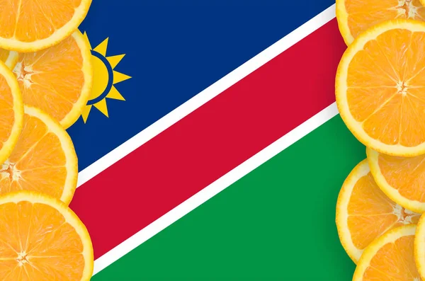 Namibia flag  in vertical frame of orange citrus fruit slices. Concept of growing as well as import and export of citrus fruits
