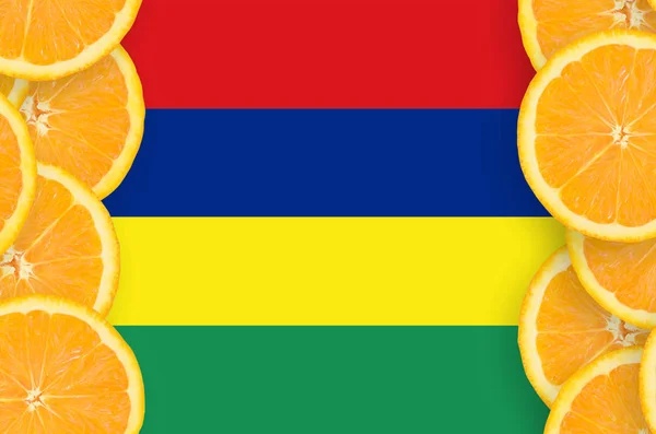毛里求斯国旗在橙色柑橘果实片的垂直框架 柑橘类水果的种植及进出口概念 — 图库照片