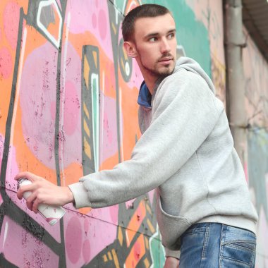 Bir genç grafiti sanatçısı çizim sırasında etrafına bakıyor. Vandal duvardaki resim çizerken undetected olmaya çalışıyor. Holiganizmi ve mülke zarar kavramı