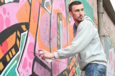 Bir genç grafiti sanatçısı çizim sırasında etrafına bakıyor. Vandal duvardaki resim çizerken undetected olmaya çalışıyor. Holiganizmi ve mülke zarar kavramı