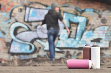 Bir fotoğraf boya belirli bir sayının üzerinde büyük grafiti çizim genç adam çizer duvar boşlukla çerçevede kutular. Duvar grafiti çizim Modern Sanat