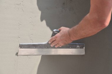 Ev yenilenen araçları sıvama duvar ile eski bir işçi elleri. Sıvacı yenilenen açık duvar ve spatula ve alçı ile köşeleri. Duvar izolasyonu. İnşaat bitirme işleri