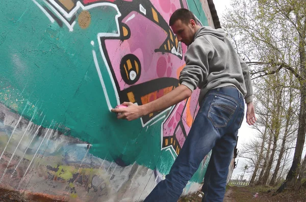 Een Jonge Man Een Grijze Hoodie Schildert Graffiti Roze Groene — Stockfoto