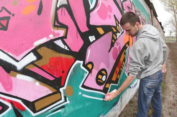 Joven Con Capucha Gris Pinta Graffiti Colores Rosa Verde Una —  Fotos de Stock