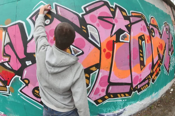 Young Guy Gray Hoodie Paints Graffiti Pink Green Colors Wall — Stock Photo, Image