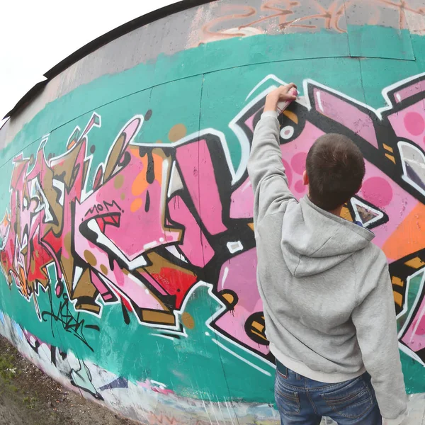 Ein Junger Mann Grauen Kapuzenpullover Malt Bei Regenwetter Graffiti Rosa — Stockfoto