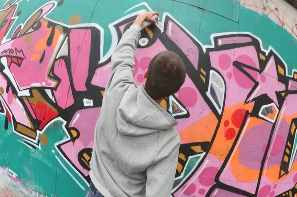 Egy Fiatal Srác Egy Szürke Kapucnis Fest Graffiti Falon Rózsaszín — Stock Fotó