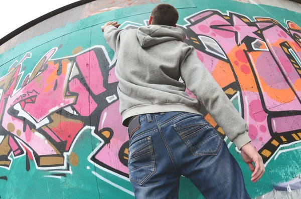 Joven Con Capucha Gris Pinta Graffiti Colores Rosa Verde Una —  Fotos de Stock