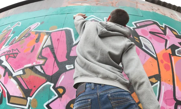 Ein Junger Mann Grauen Kapuzenpullover Malt Bei Regenwetter Graffiti Rosa — Stockfoto