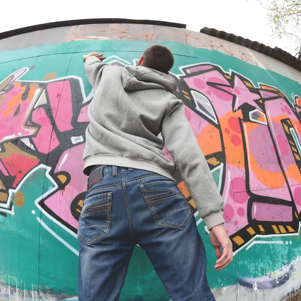 Een Jonge Man Een Grijze Hoodie Schildert Graffiti Roze Groene — Stockfoto