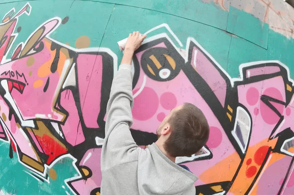 Ein Junger Mann Grauen Kapuzenpullover Malt Bei Regenwetter Graffiti Rosa — Stockfoto