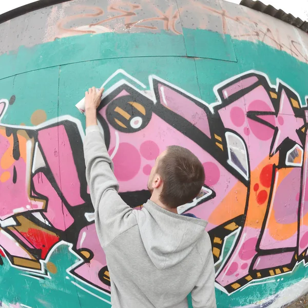 Joven Con Capucha Gris Pinta Graffiti Colores Rosa Verde Una —  Fotos de Stock