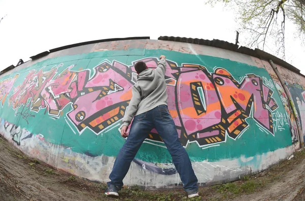 Ein Junger Mann Grauen Kapuzenpullover Malt Bei Regenwetter Graffiti Rosa — Stockfoto