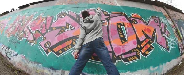 Joven Con Capucha Gris Pinta Graffiti Colores Rosa Verde Una —  Fotos de Stock