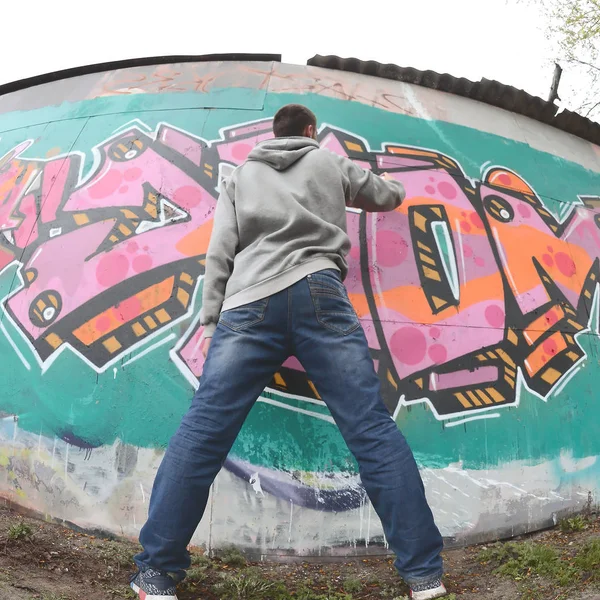 Ragazzo Giovane Con Una Felpa Grigia Dipinge Graffiti Colori Rosa — Foto Stock