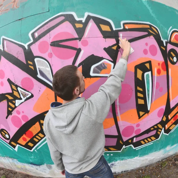 Joven Con Capucha Gris Pinta Graffiti Colores Rosa Verde Una —  Fotos de Stock