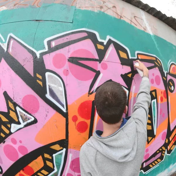 Joven Con Capucha Gris Pinta Graffiti Colores Rosa Verde Una —  Fotos de Stock