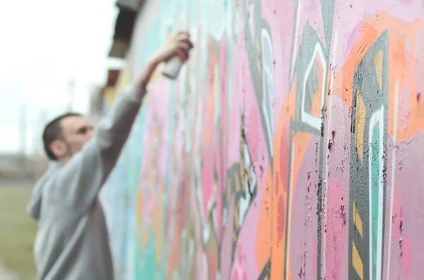 Joven Con Capucha Gris Pinta Graffiti Colores Rosa Verde Una — Foto de Stock