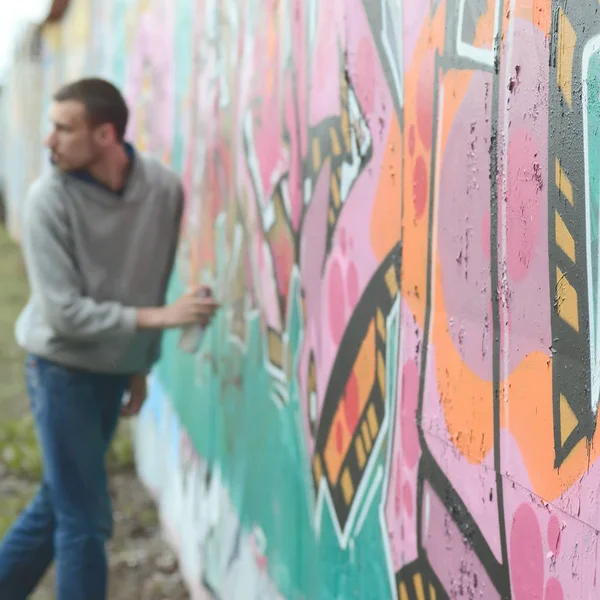 Young Guy Gray Hoodie Paints Graffiti Pink Green Colors Wall — Stock Photo, Image