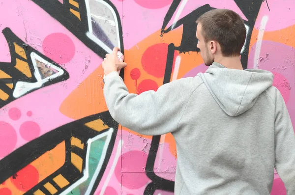 Joven Con Capucha Gris Pinta Graffiti Colores Rosa Verde Una — Foto de Stock