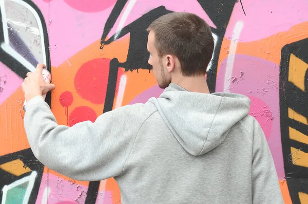 Joven Con Capucha Gris Pinta Graffiti Colores Rosa Verde Una — Foto de Stock