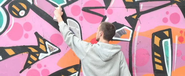 Joven Con Capucha Gris Pinta Graffiti Colores Rosa Verde Una — Foto de Stock