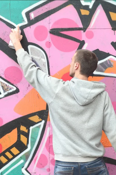 Joven Con Capucha Gris Pinta Graffiti Colores Rosa Verde Una — Foto de Stock