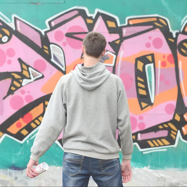 Giovane Graffitista Con Una Felpa Grigia Guarda Muro Con Suoi — Foto Stock