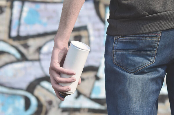 Фотография уличного художника, который рисует новую цветную картину на кирпичной стене. Одним из видов стрит-арта является молодежная граффити-культура. Оформление стен старых и заброшенных зданий
