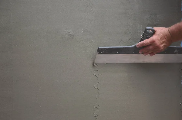 老手工工作者的手与墙壁抹灰工具整修房子 泥水匠用刮刀和石膏翻新户外墙壁和角落 墙体绝缘 建筑整理工程 — 图库照片
