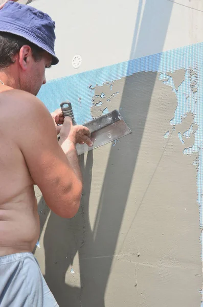 Fifty years old manual worker with wall plastering tools renovating house. Plasterer renovating walls and corners with spatula and plaster. Wall mash installation. Construction finishing works — Stock Image Fifty Years Old Manual Worker Wall Plastering Tools Renovating House Royalty Free Stock Photos