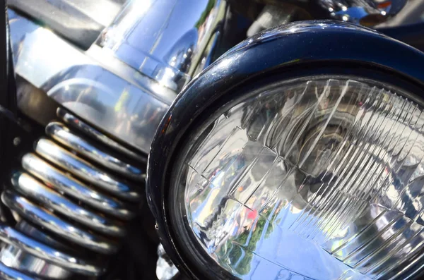 Close up fragment of chromed shiny lamp of old classic motorbike