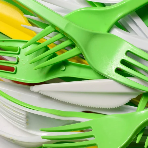 Pile of bright yellow, green and white used plastic kitchenware appliances. Ecological problem. Plastic pollution