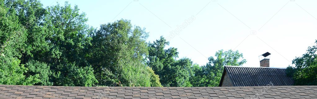 Modern roofing and decoration of chimneys. Flexible bitumen or slate shingles in rectangular shape in perspective.