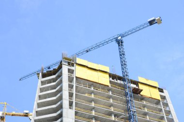 İnşaat alanında. Yüksek çok katlı binaların yapım aşamasında. Kule vinç yakınındaki binalar