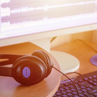 Büyük siyah kulaklık ses Tasarımcısı ahşap masaüstünde yalan. İş yeri için müzik yaratıcısı. Seçici odak