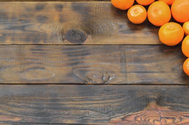 Bir sürü taze portakal mandalina yalan kahverengi ahşap arka plan üzerinde. Meyve mezarda düz yatırın